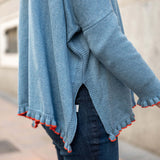 Aegan blue ruffled cotton sweater with vermillion accents on the hem and cuffs.