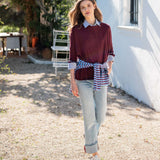 MERSEA women's travel-friendly burgundy and sapphire blue striped ruffle sweater with a buttoned collar, worn over denim jeans.