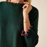 Forest green knit sweater with bubblegum pink ruffled trim.
