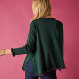 Back view of the forest green cotton ruffle sweater with a ruffled hem.