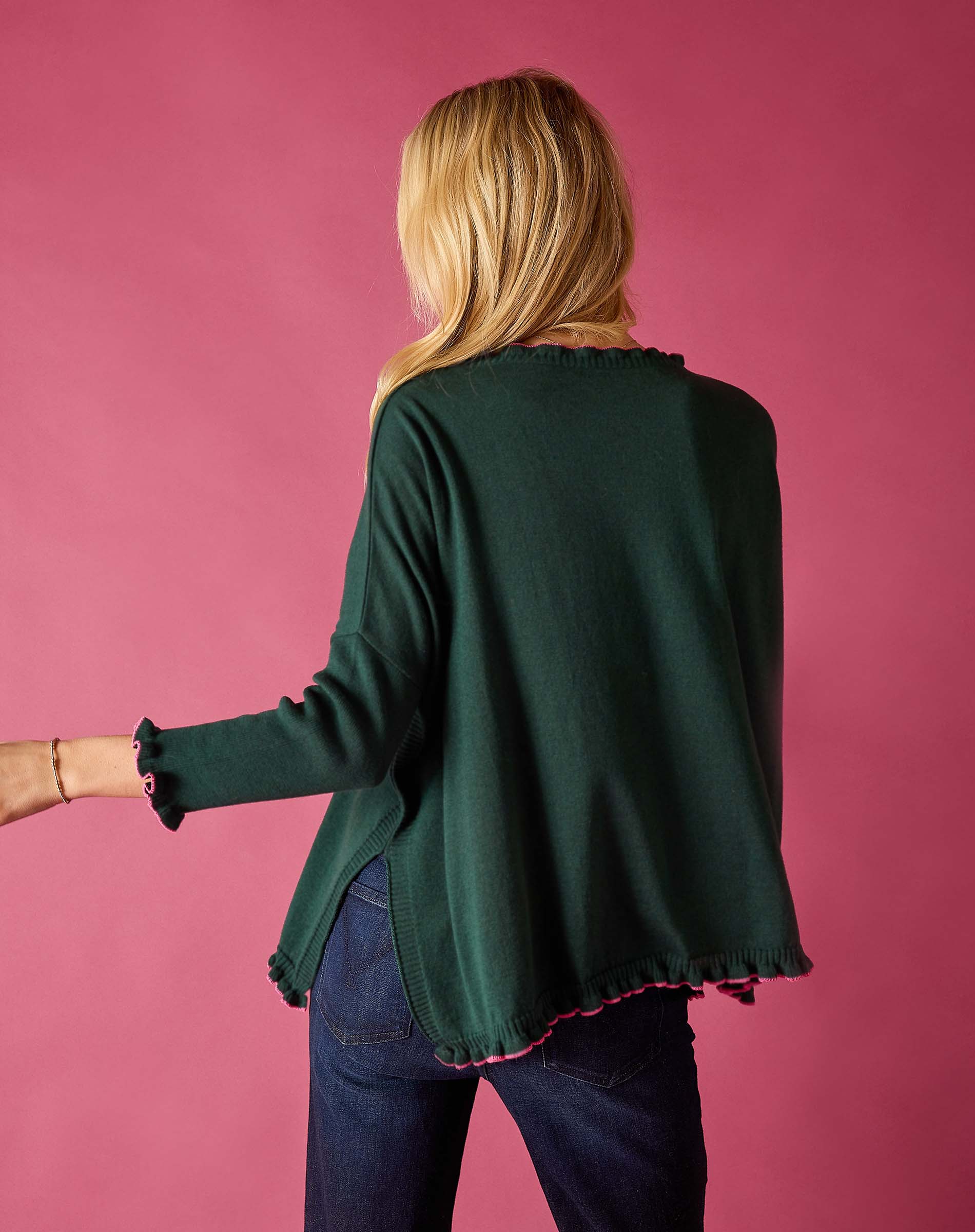 Back view of the forest green cotton ruffle sweater with a ruffled hem.