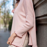 Light orchid ruffle knit sweater with a relaxed fit and ruffled edges.