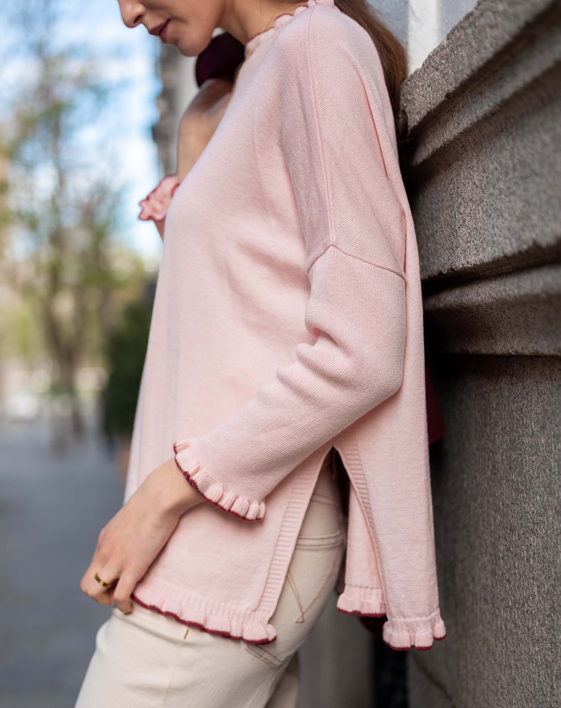Light orchid ruffle knit sweater with a relaxed fit and ruffled edges.