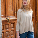 Natural beige cotton ruffle sweater with a loose fit and ruffled hem for women.