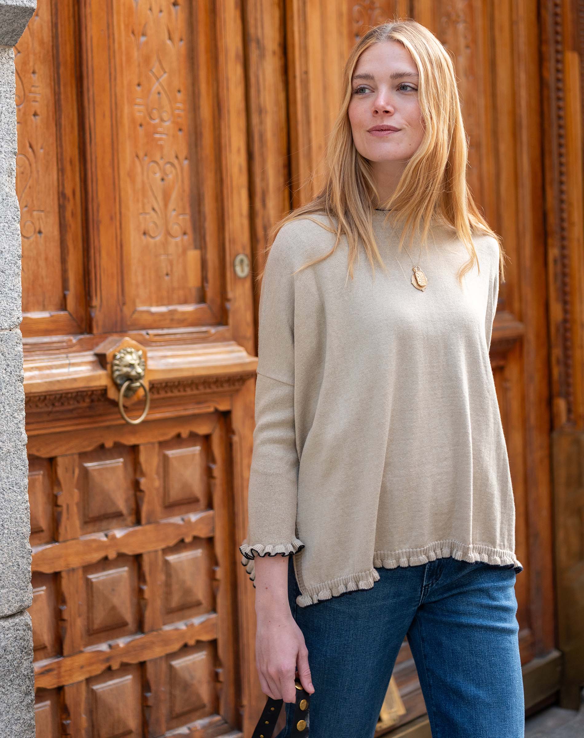 Natural cotton ruffle sweater with a relaxed fit and ruffled hem detail.