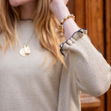 Natural and black ruffled cuff detail on a soft, knit cotton sweater.