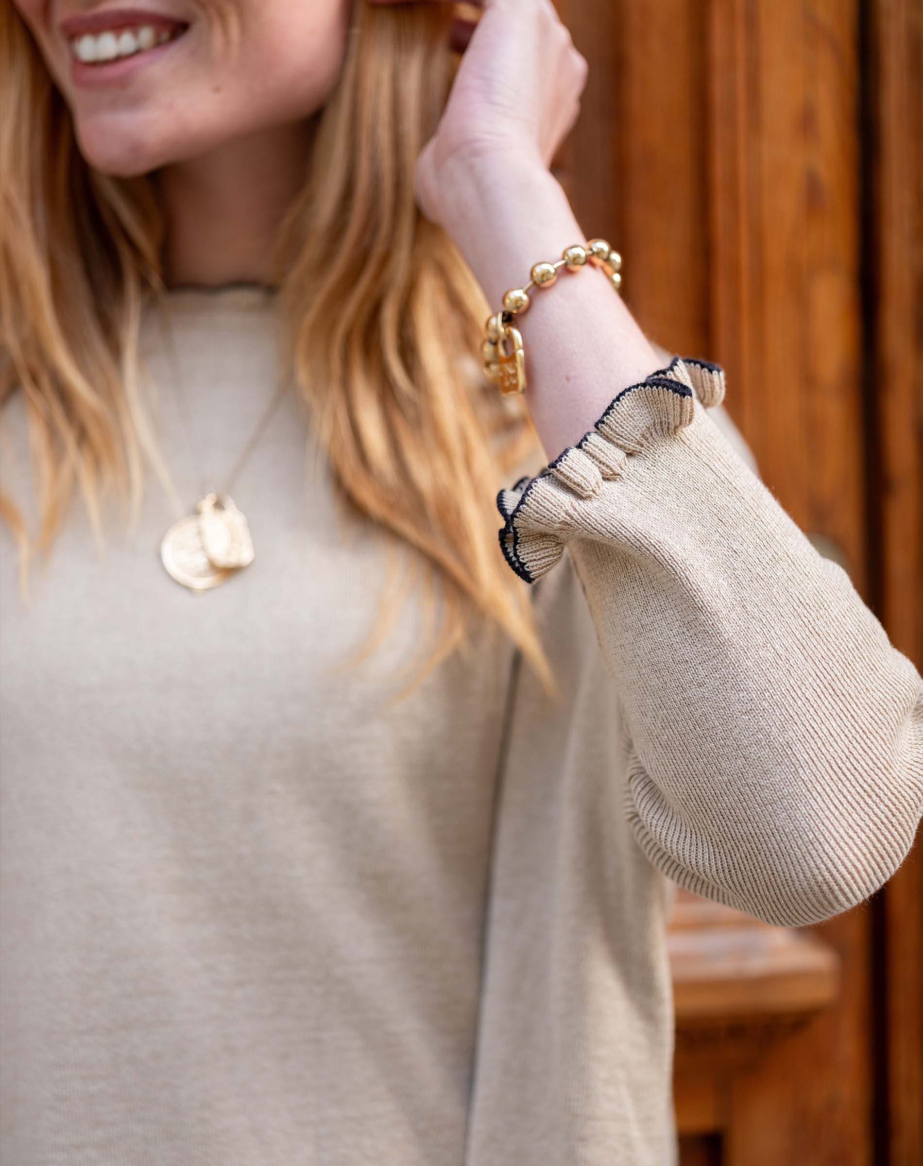 Natural and black ruffled cuff detail on a soft, knit cotton sweater.