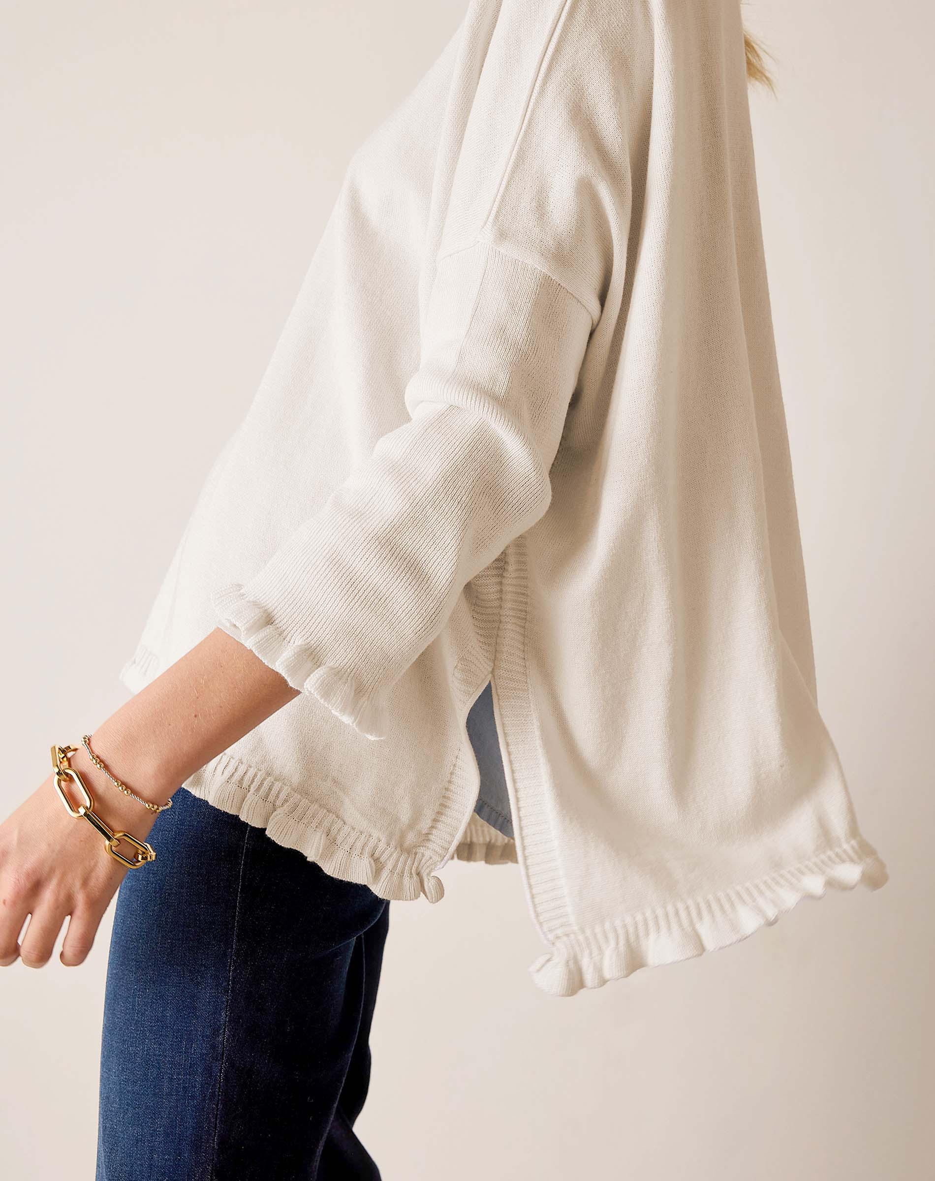 Warm white ruffled cotton knit sweater with 3/4 sleeves and a wide hem.