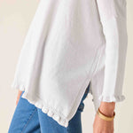 White blouse with ruffled sleeves worn by a person, with a plain background