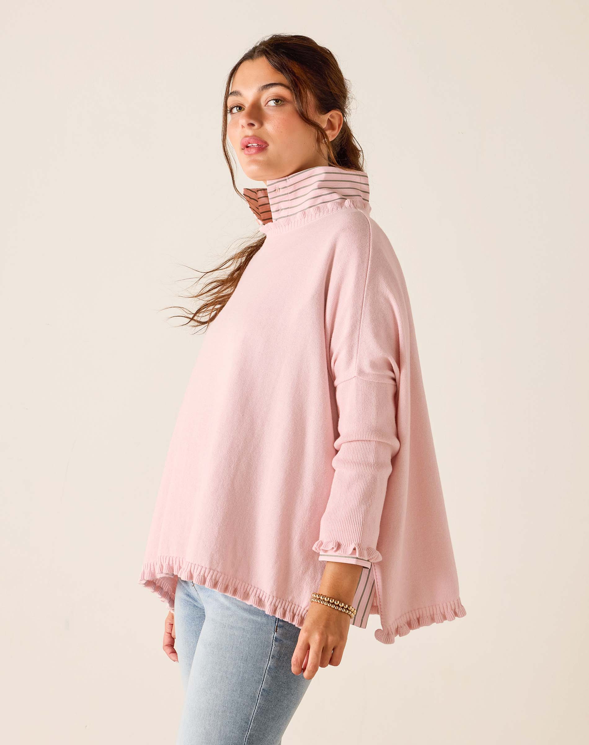 Woman wearing a pink turtleneck sweater against a plain background