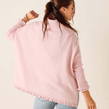 Person wearing a pink sweater with a white background
