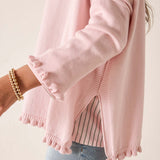 Pink sweater worn by a person on a light background