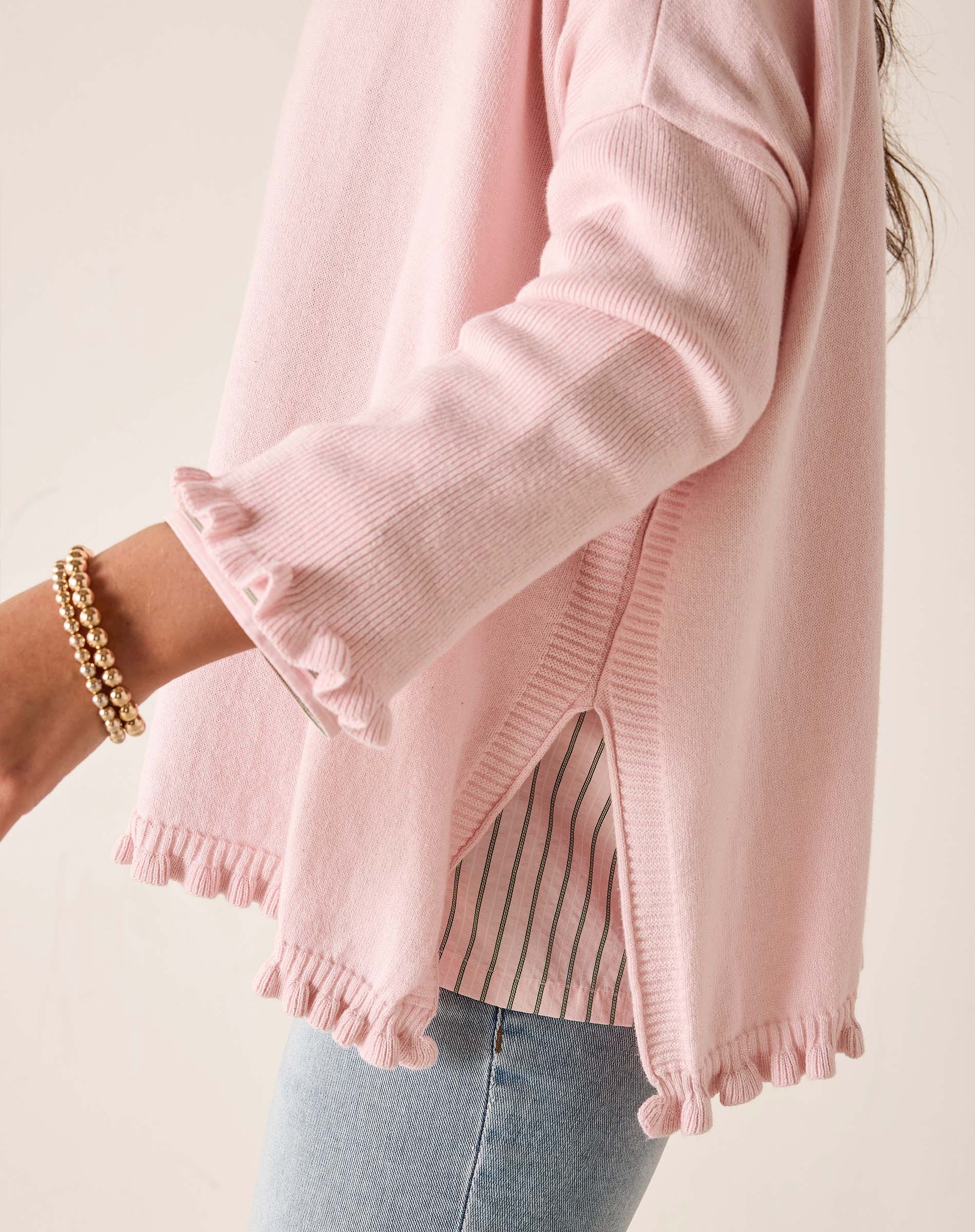 Pink sweater worn by a person on a light background