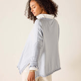 Woman wearing a light blue jacket with white trim on a beige background