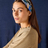 Woman wearing a patterned headband against a dark blue background