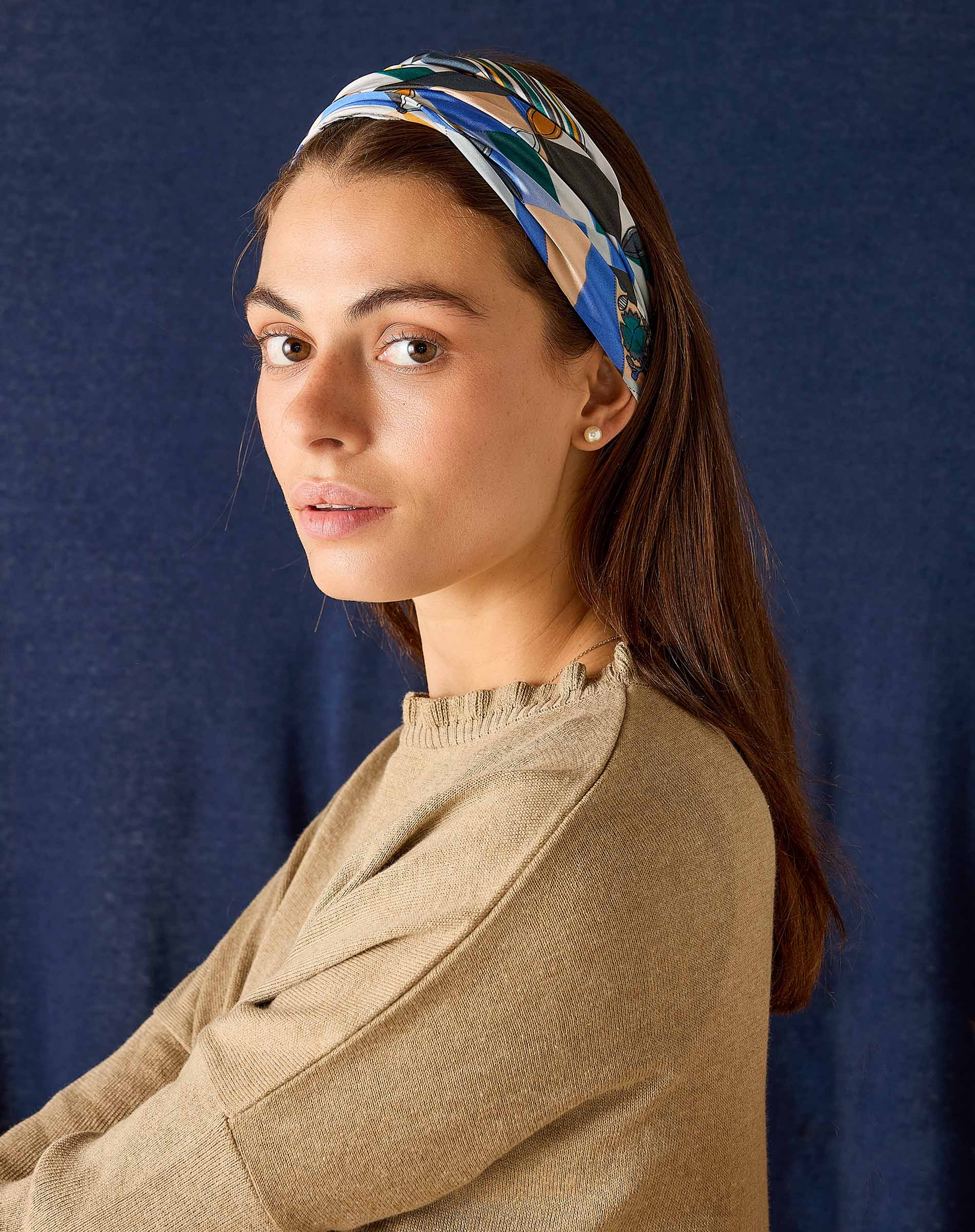 Woman wearing a patterned headband against a dark blue background