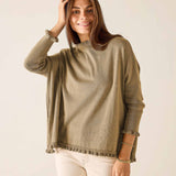 Woman wearing a green sweater against a plain background