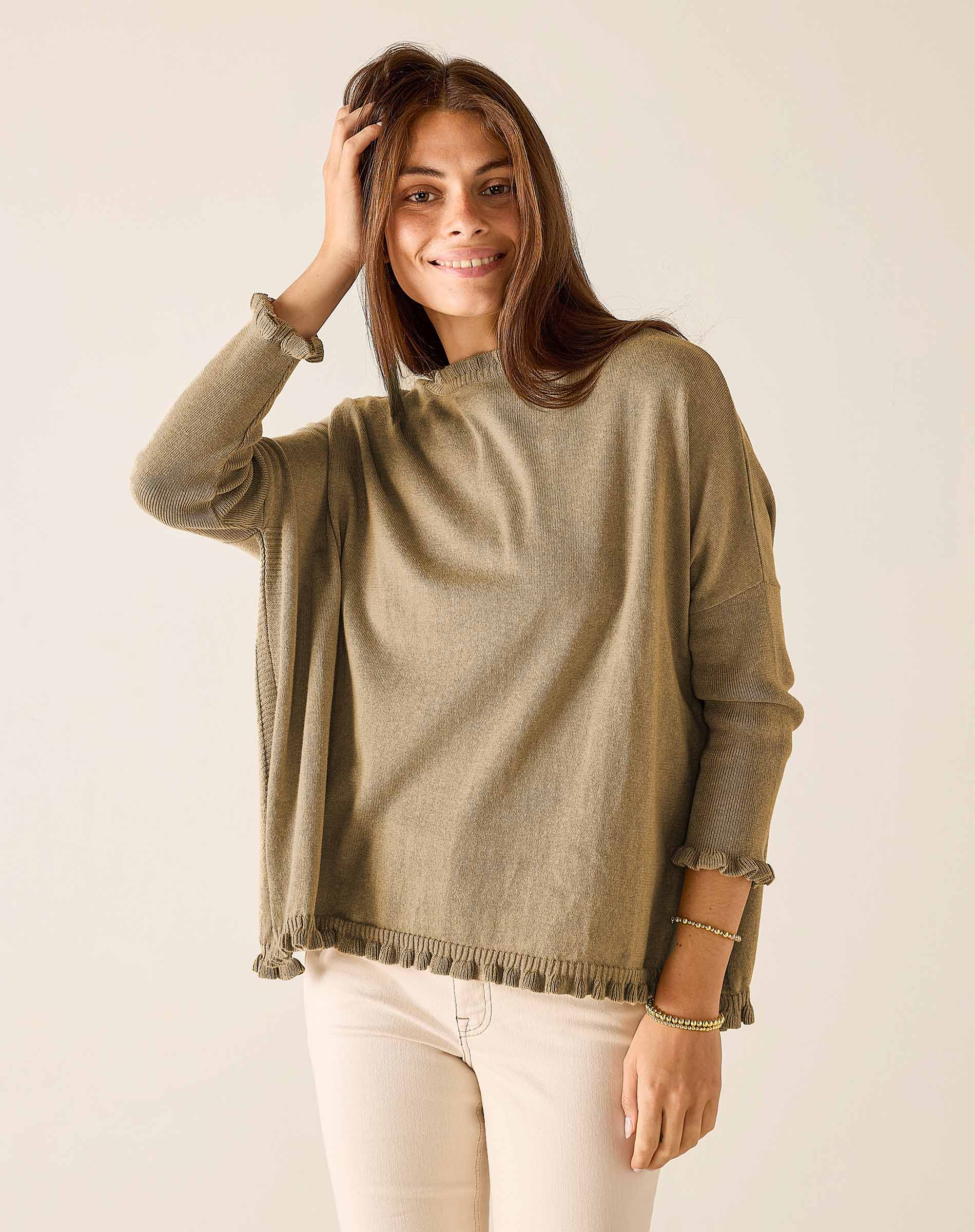 Woman wearing a green sweater against a plain background