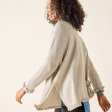 Woman wearing a beige cardigan with a white background