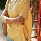 Person wearing a yellow sweater with a blurred background