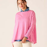 Woman wearing a pink sweater with a white background