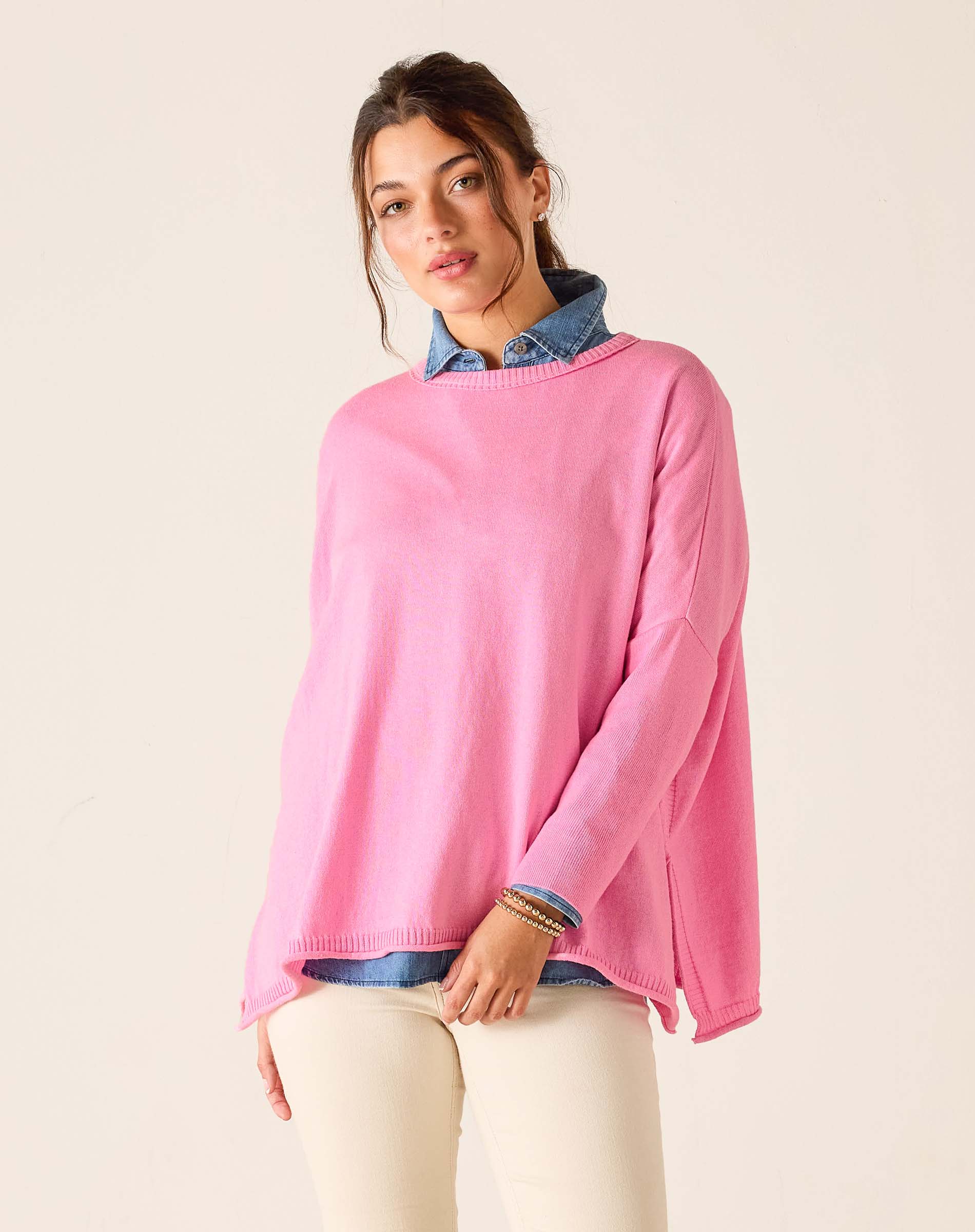 Woman wearing a pink sweater with a white background