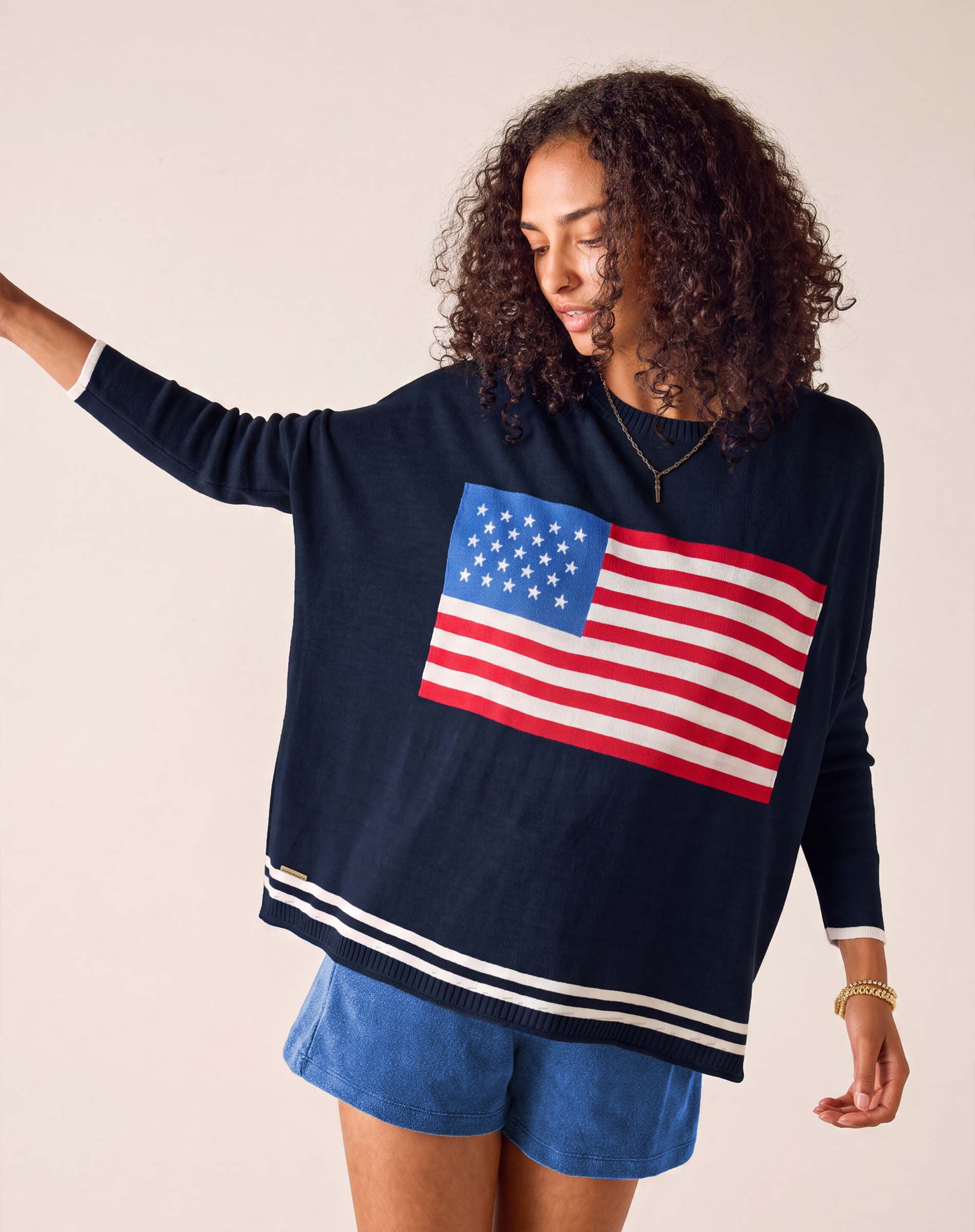 MERSEA women's travel-friendly navy blue crewneck knit top with an American flag graphic and striped hem.