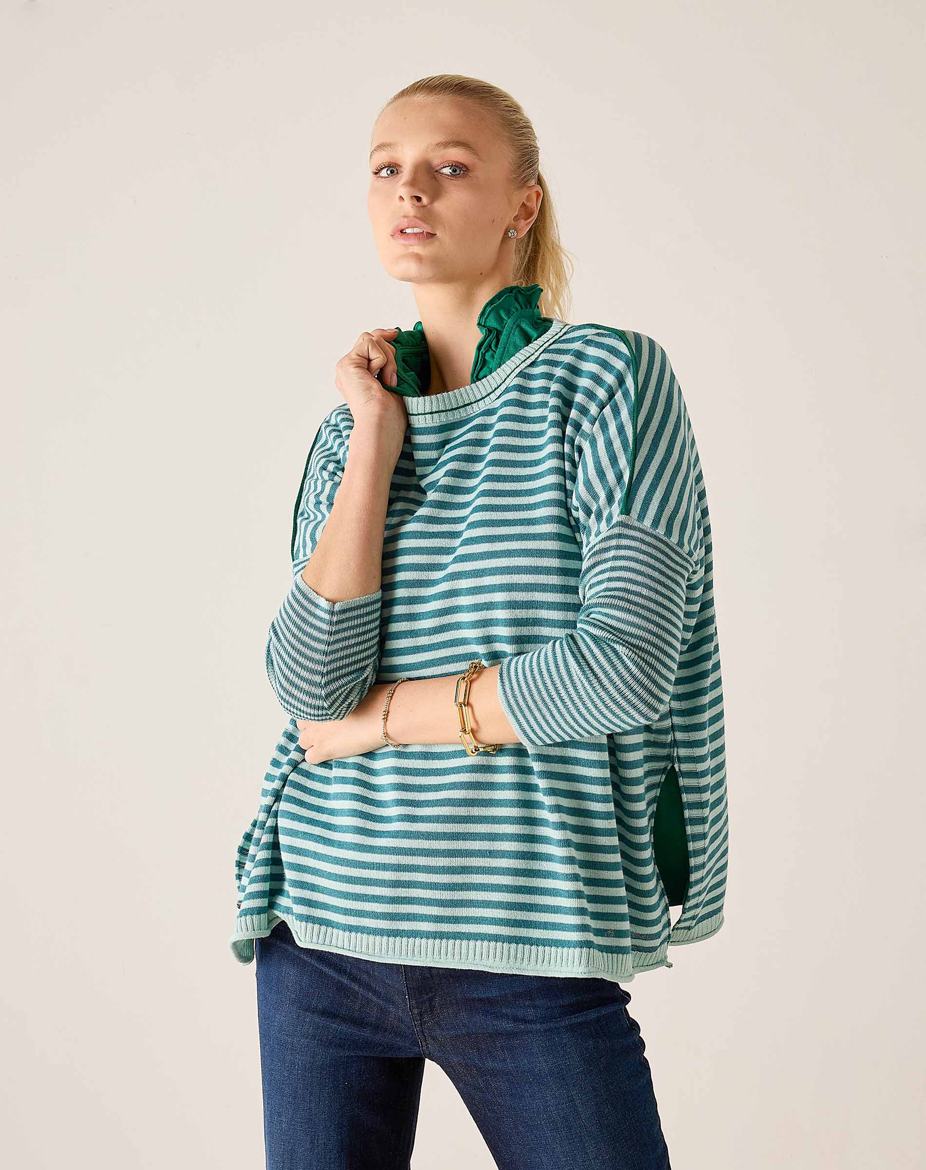 Model wearing the Catalina crewneck knit top in deep ocean rain stripes with navy jeans.