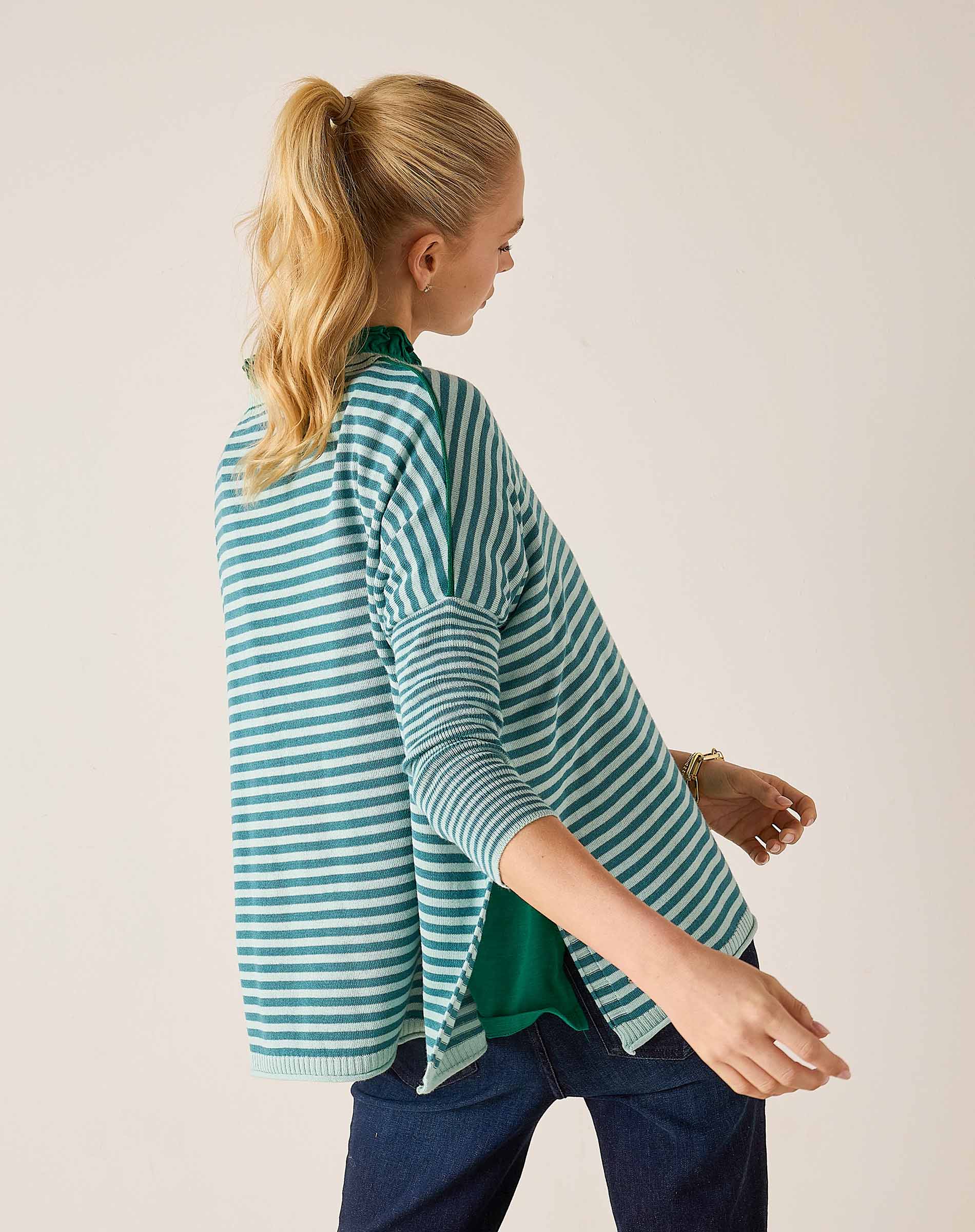 Side view of the deep ocean rain horizontal striped crewneck knit top with three-quarter sleeves.
