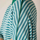 Close-up of a deep ocean rain green and white striped knit crewneck with a ribbed trim.