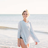 Woman wearing a light blue cover-up on a beach