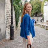 Woman in a blue jacket walking down a street