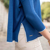 Blue jacket with white trim worn by a person, blurred background