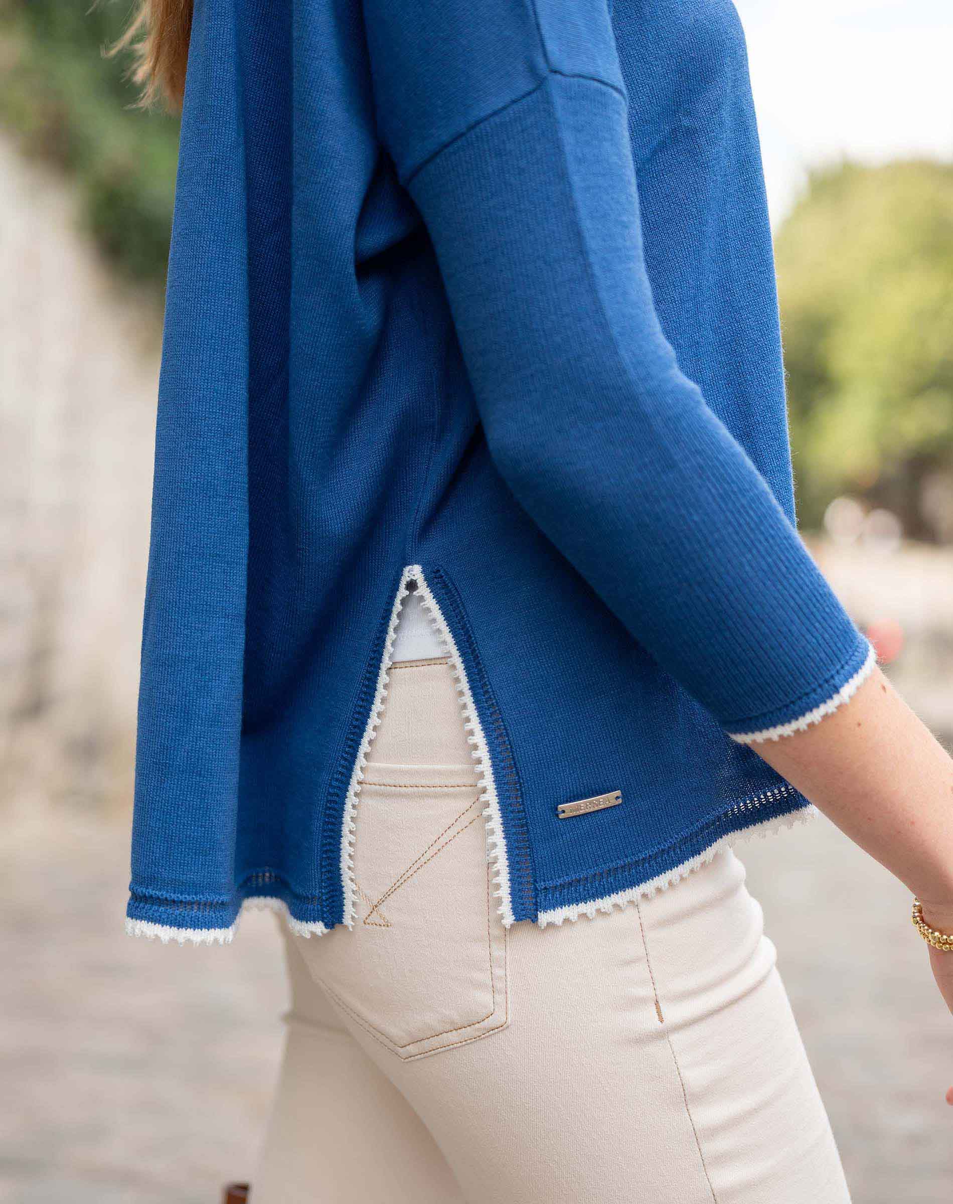 Blue jacket with white trim worn by a person, blurred background