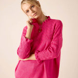 Women's travel-friendly fuchsia textured knit sweater featuring a decorative open-work pattern.