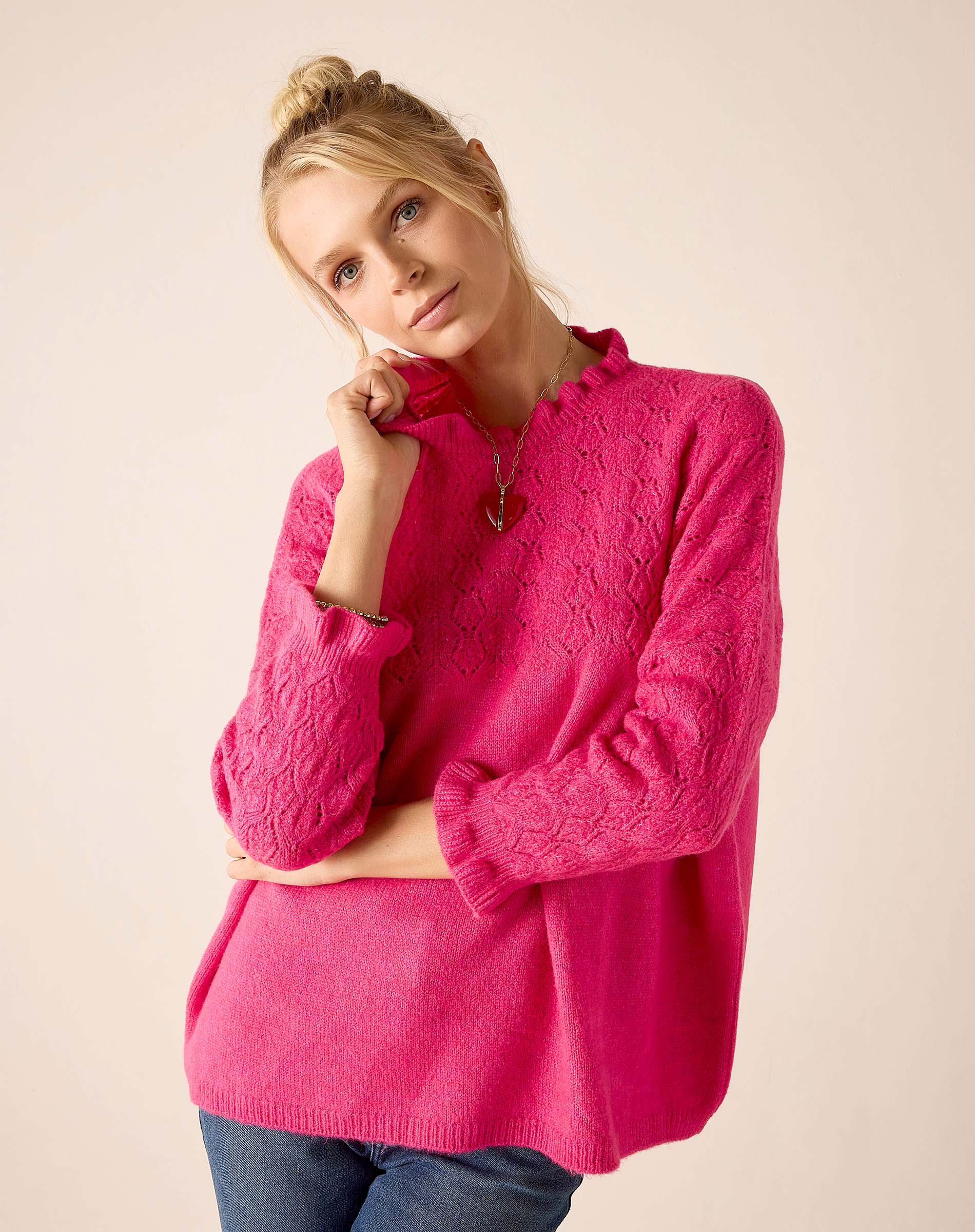 Women's travel-friendly fuchsia textured knit sweater featuring a decorative open-work pattern.