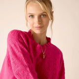 Fuchsia knit sweater with a geometric weave pattern.
