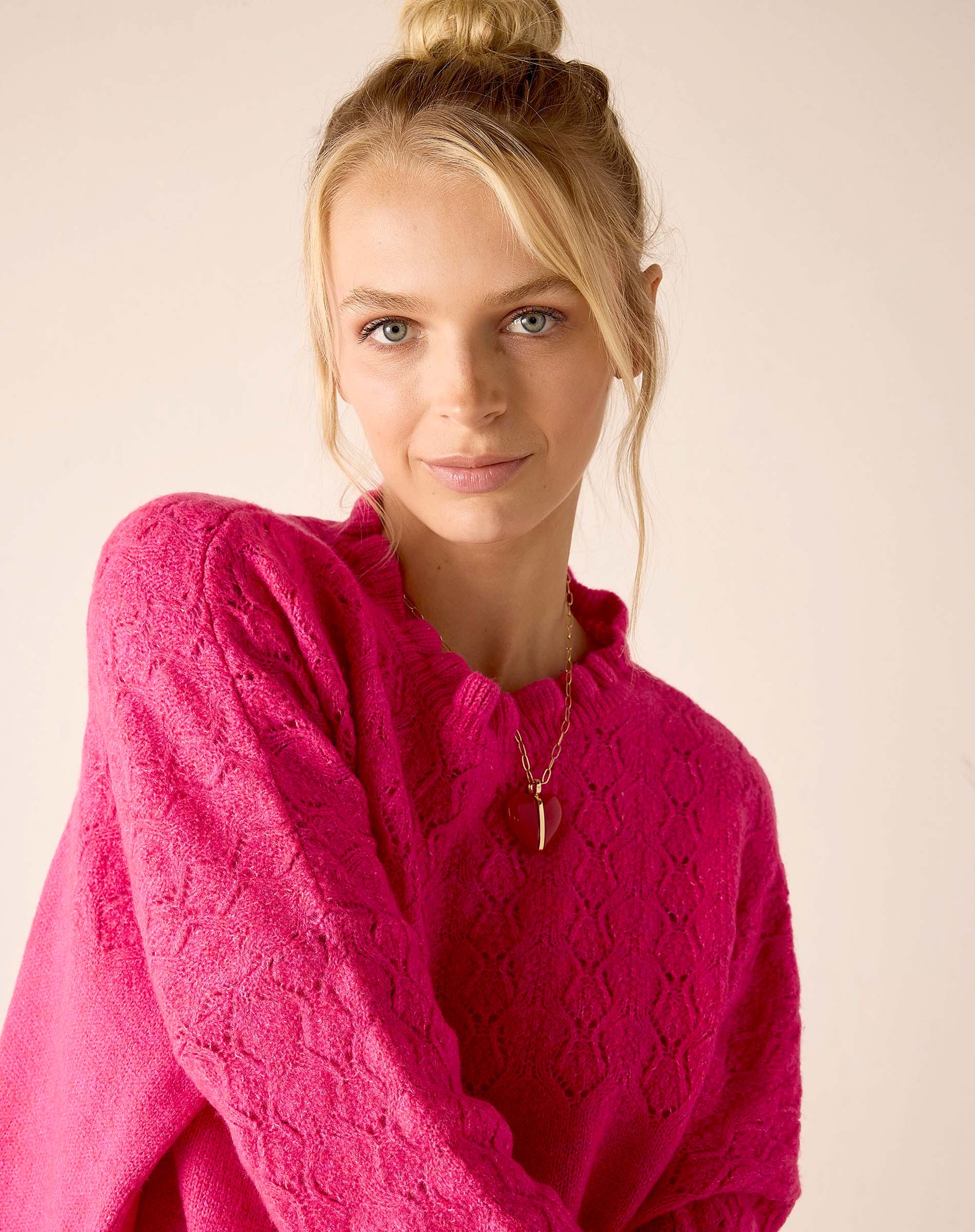 Fuchsia knit sweater with a geometric weave pattern.