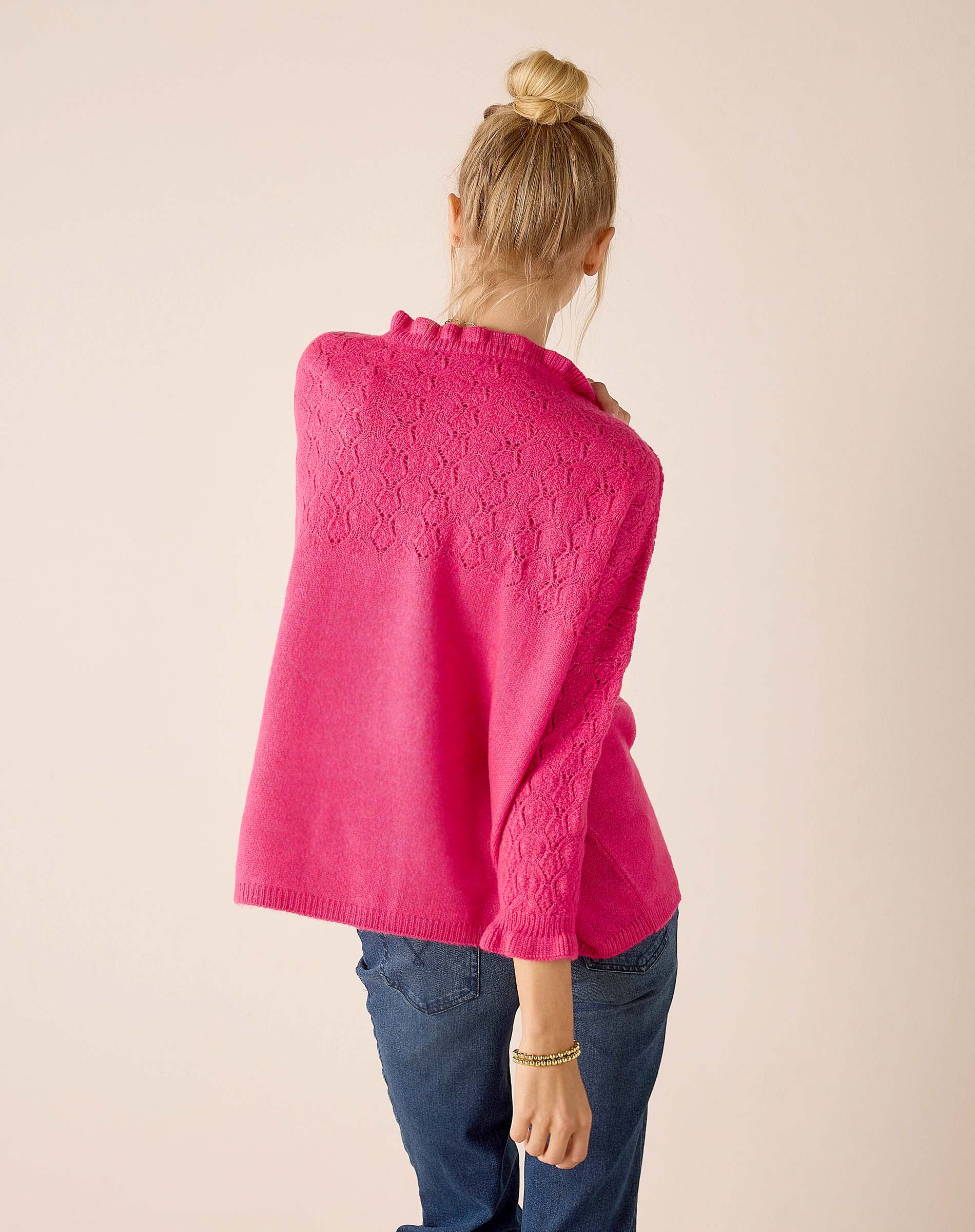 Back view of women's travel-friendly fuchsia knit poncho with open lace detailing.