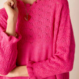 Fuchsia open-stitch knit sweater with a relaxed fit and intricate pointelle pattern.