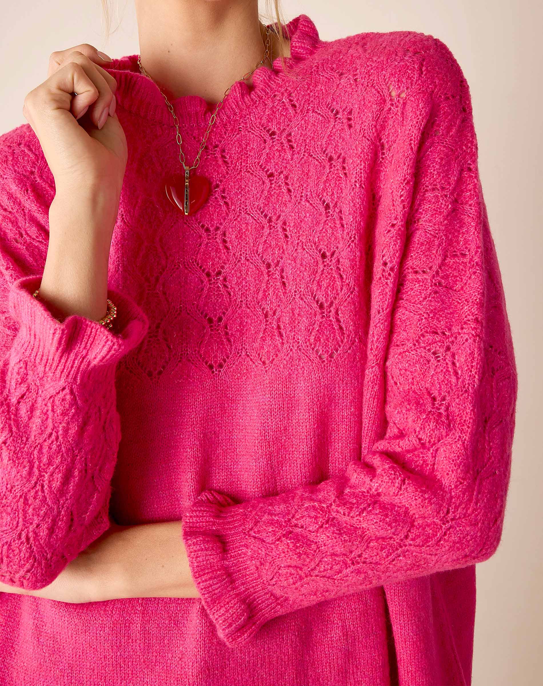 Fuchsia open-stitch knit sweater with a relaxed fit and intricate pointelle pattern.