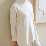 Cream chenille sweater with a high neck and relaxed fit.