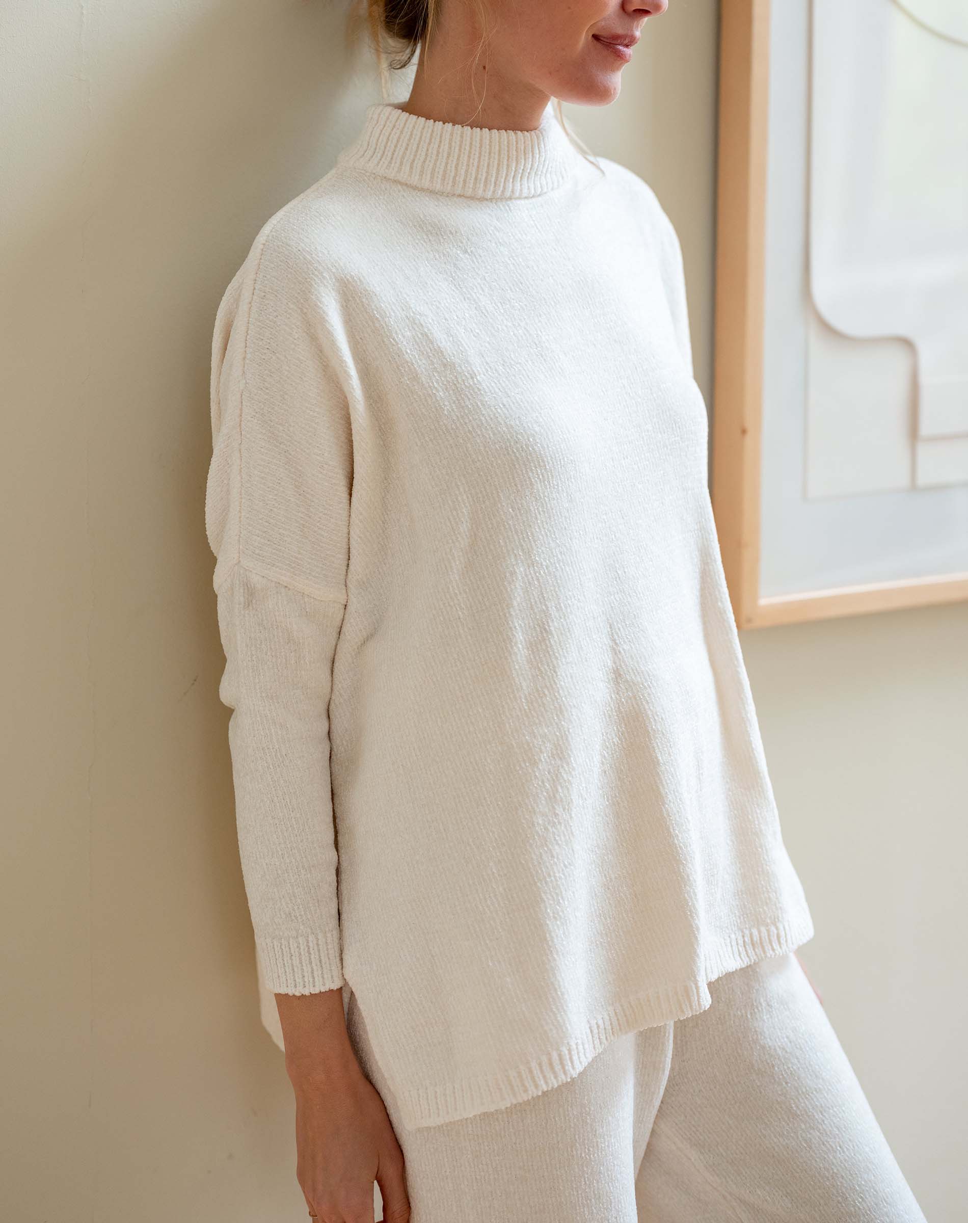 Cream chenille sweater with a high neck and relaxed fit.