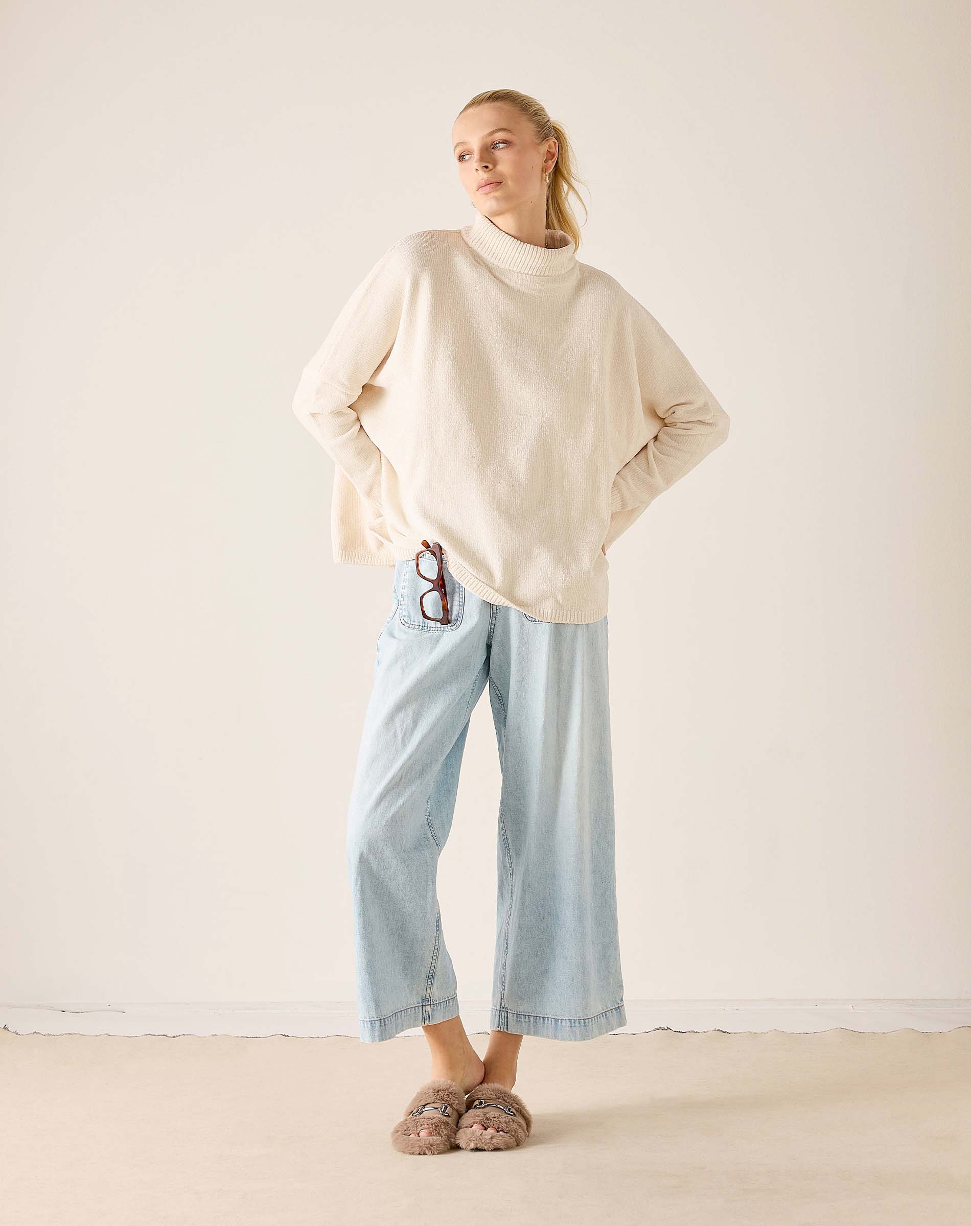 Women's travel-friendly cream mockneck knit sweater with a relaxed fit.