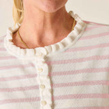 Close-up of a person wearing a pink and white striped shirt with a gold necklace.