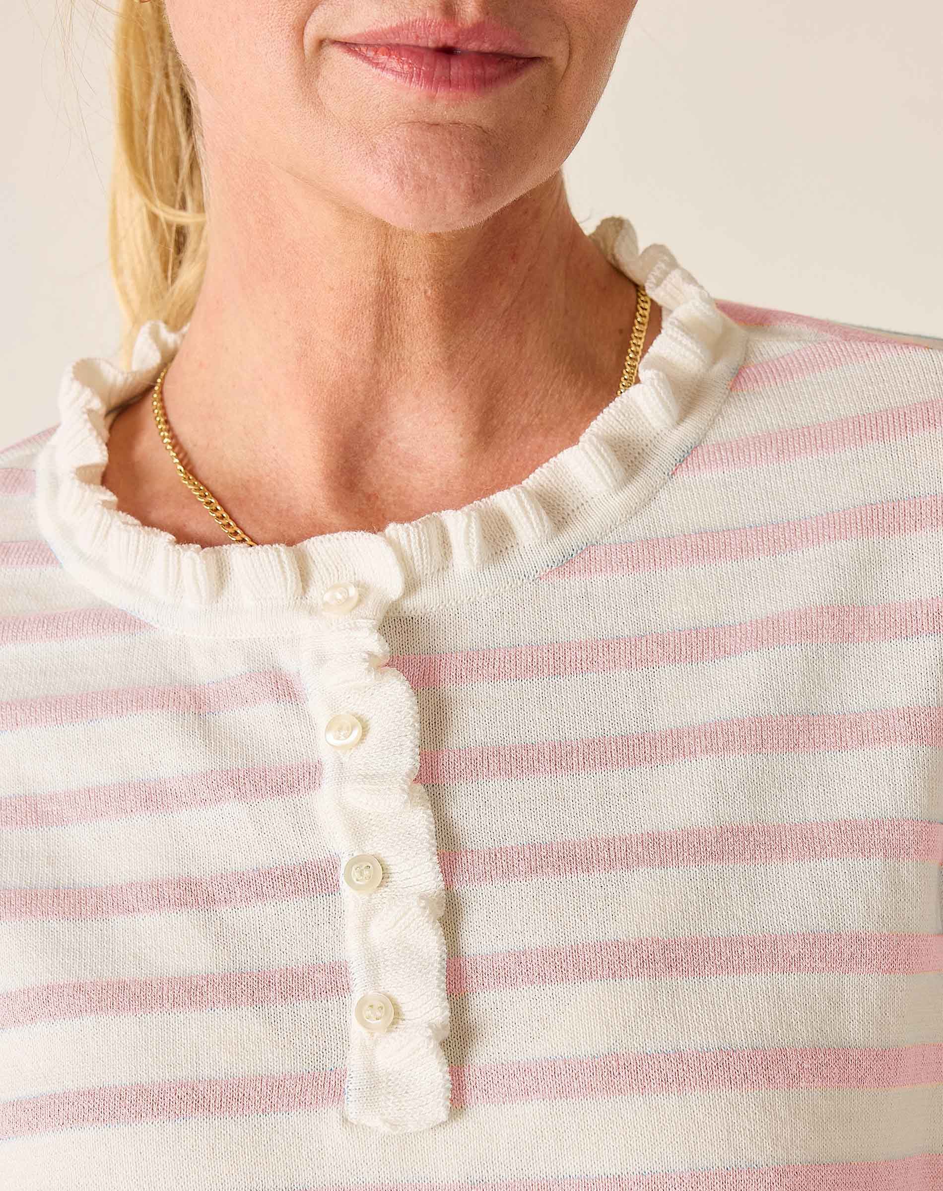 Close-up of a person wearing a pink and white striped shirt with a gold necklace.