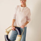 Woman holding a life preserver against a plain background