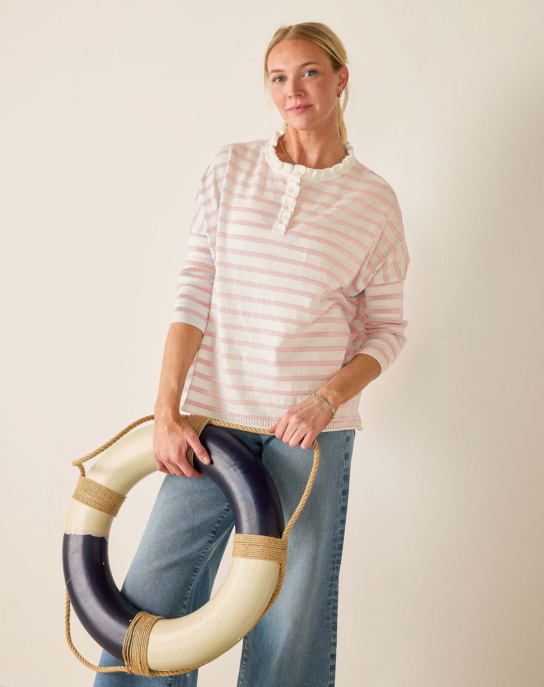 Woman holding a life preserver against a plain background