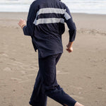Person wearing a navy raincoat with white stripes on a beach