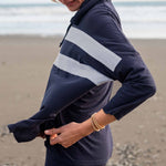 Person wearing a navy and white striped hoodie on a beach